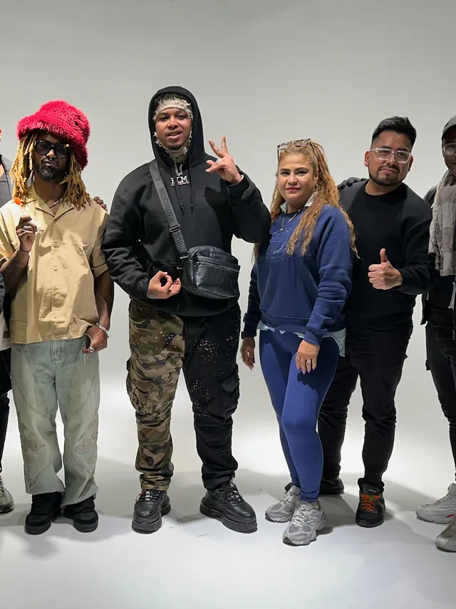 El Dray y Macuto con artistas y el equipo en un plató blanco, tras un rodaje
