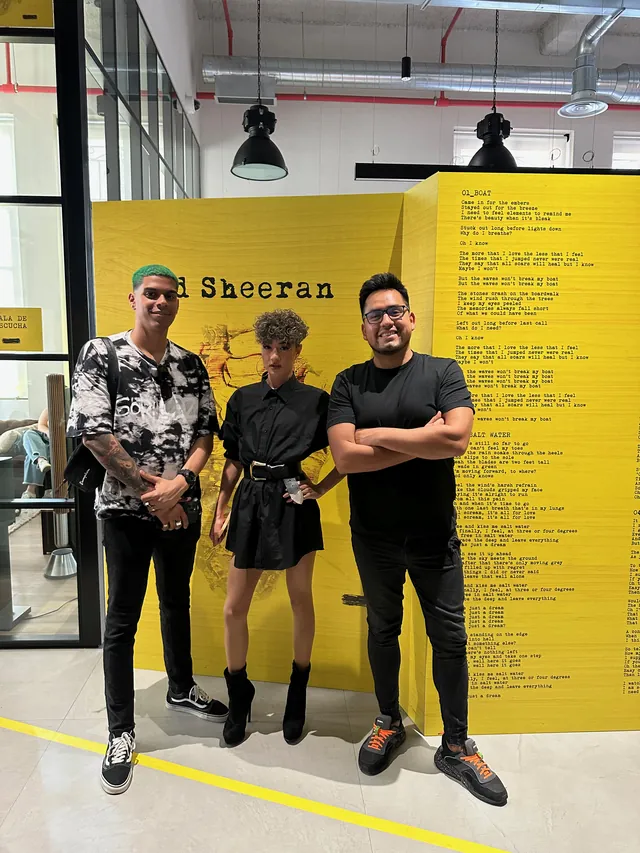 Macuto y dos personas ante el panel amarillo de Ed Sheeran en Warner Chappell Music