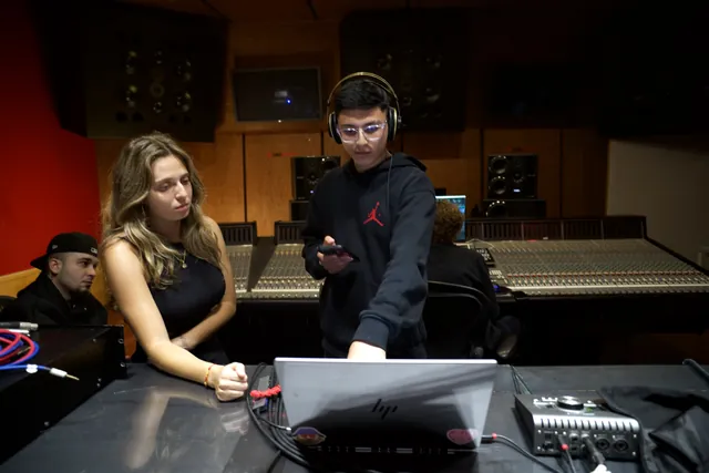 Una artista y un productor trabajan en la mesa de mezclas de PKO Studios